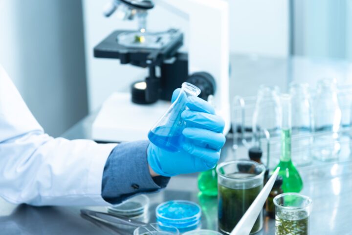 person-holding-laboratory-flask