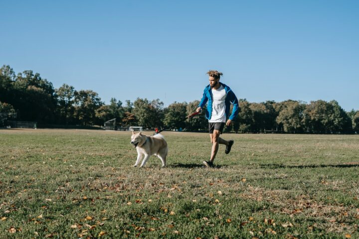 happy-man-running-with-dog-in-park