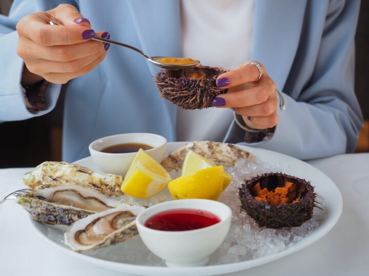close-up-of-woman-eating-oysters-in-restaurant